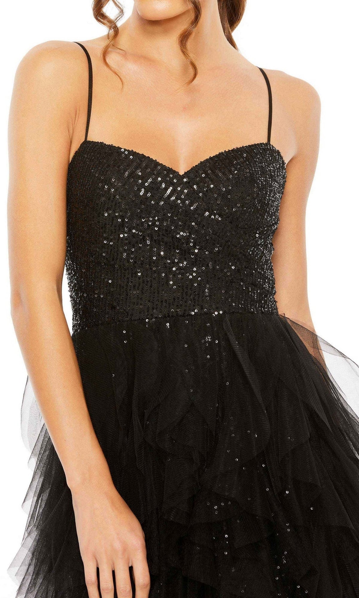 A woman wears the Mac Duggal 27119 Overskirt Mini Sequin Prom Dress, featuring thin straps and a layered tulle skirt—an elegant choice for any evening event.